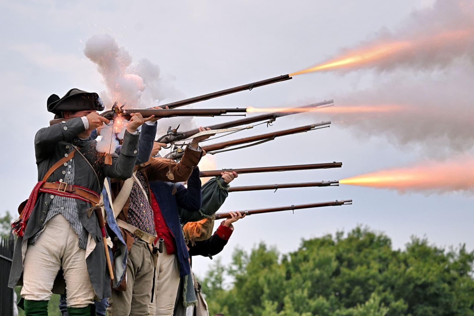 A photo of Revolutionary War re-enactors firing muskets